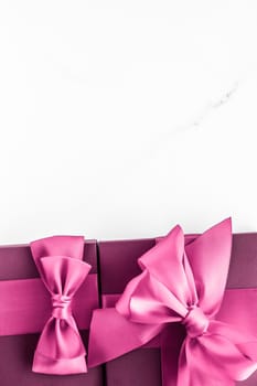 Birthday, wedding and girly branding concept - Pink gift box with silk bow on marble background, girl baby shower present and glamour fashion gift for luxury beauty brand, holiday flatlay art design