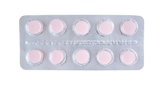 Pink tablets in blister isolated on a white background.