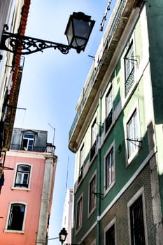 Old colorful and majestic tiled facades with vintage streetlight in Lisbon streets in Spring.