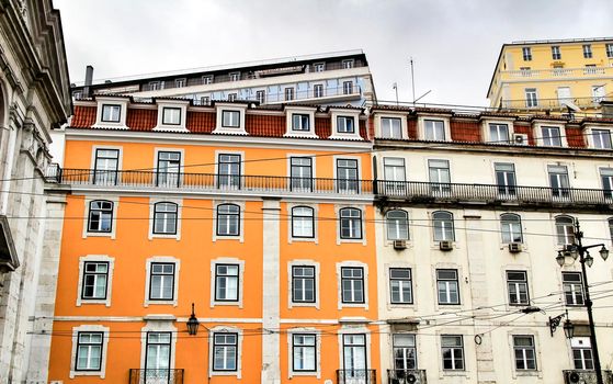 Old colorful and beautiful facades with vintage streetlight in Lisbon streets in Spring. Clothesline in the facade with hanging clothes