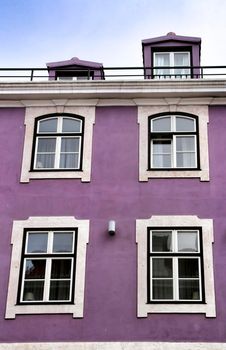 Old colorful and beautiful facades with vintage streetlight in Lisbon streets in Spring. Clothesline in the facade with hanging clothes