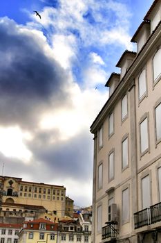 Old colorful and beautiful facades with vintage streetlight in Lisbon streets in Spring. Clothesline in the facade with hanging clothes