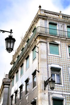 Old colorful and beautiful facades with vintage streetlight in Lisbon streets in Spring. Clothesline in the facade with hanging clothes