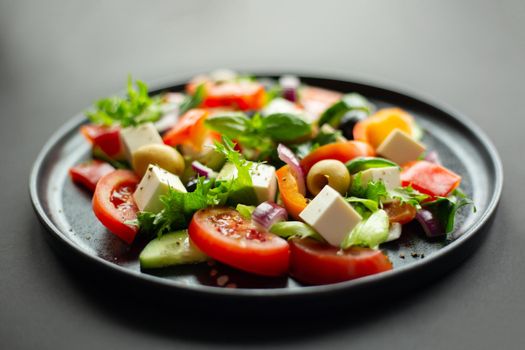 Greek salad side view on black table over black table background