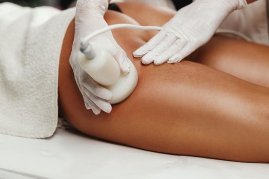 Shot of an unrecognizable woman getting anti cellulite massage at the beauty salon. She have an ultrasound cavitacion treatment to fat reduction.