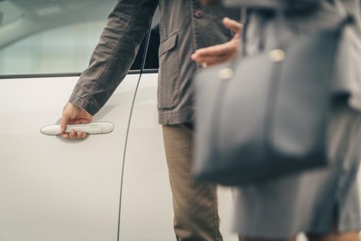 Cropped shot of an unrecognizable male chauffeur opening a car door.