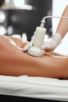 Shot of an unrecognizable woman getting anti cellulite massage at the beauty salon. She have an ultrasound cavitacion treatment to fat reduction.