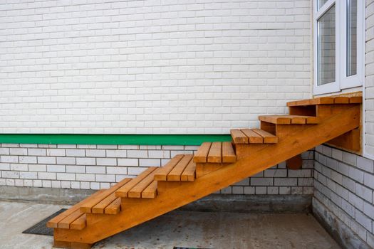 Wooden staircase painted with stain, entrance to the house.