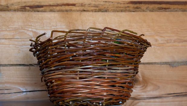 An empty wicker willow basket on a wooden background.