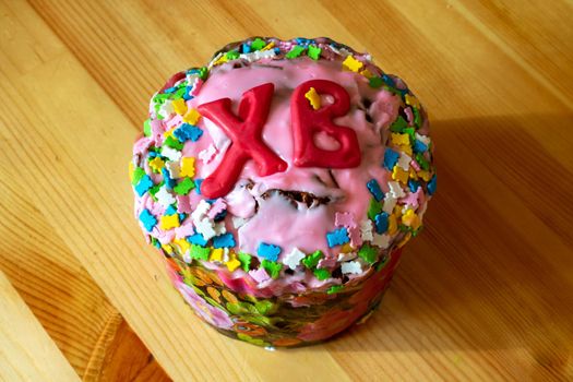Easter cake, isolated on a wooden table, close-up view. Traditional Easter cake decorated with pink meringue.
