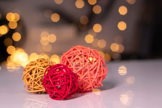 orange, red and pink wicker balls for decoration on a background of golden bokeh.