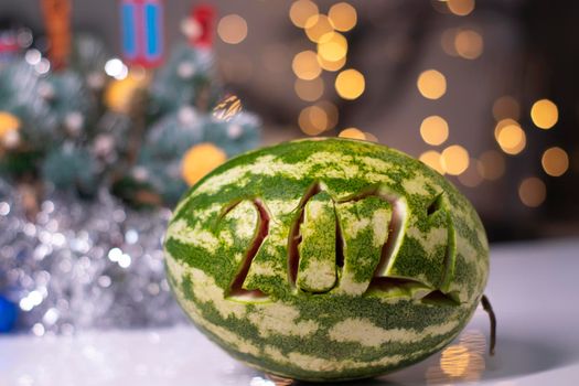 watermelon with 2021 carved number next to new year decorations. christmas theme.