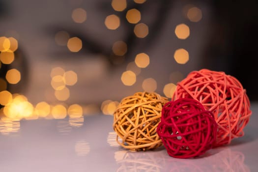 orange, red and pink wicker balls for decoration on a background of golden bokeh.