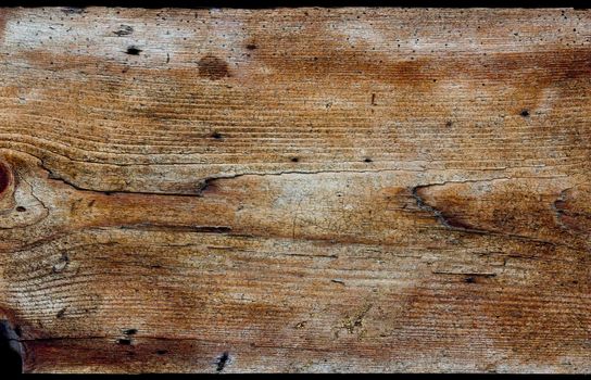 A horizontal rustic wooden board of aged wood. The wood is weathered, heavily textured and coloured yellow, gold and brown.