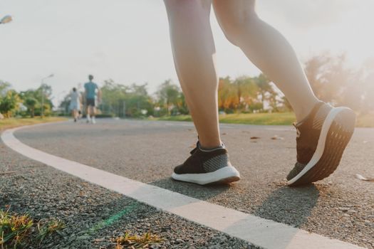 Woman wear running shoe on to walking and running on nature green background.Health exercise concept.