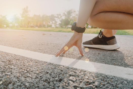 Woman wear running shoe on to walking and running on nature green background.Health exercise concept.