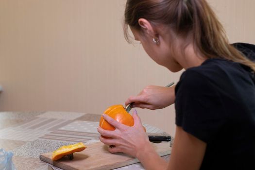 the process of making a Halloween pumpkin. cleansing of seeds by a brunette girl. horror theme and Hallowe'en.