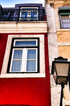 Old colorful and beautiful facades with vintage streetlight in Lisbon streets in Spring. Clothesline in the facade with hanging clothes