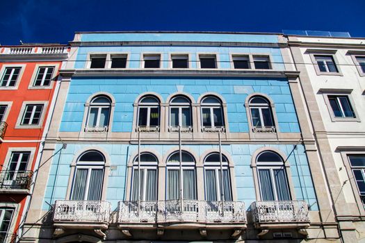Old colorful and beautiful facades with vintage streetlight in Lisbon streets in Spring. Clothesline in the facade with hanging clothes
