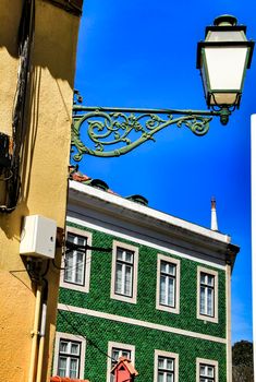 Old colorful and beautiful facades with vintage streetlight in Lisbon streets in Spring. Clothesline in the facade with hanging clothes