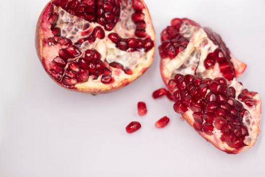 ripe fresh sliced pomegranate fruit with red seeds isolated on white background