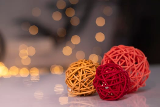 orange, red and pink wicker balls for decoration on a background of golden bokeh.