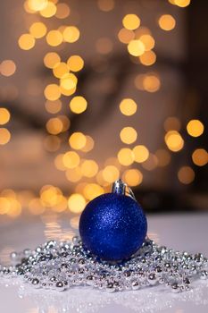 blue Christmas ball toy on a background of golden bokeh. new year theme.