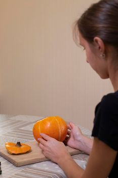 the process of making a Halloween pumpkin. cleansing of seeds by a brunette girl. horror theme and Hallowe'en.