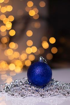 blue Christmas ball toy on a background of golden bokeh. new year theme.