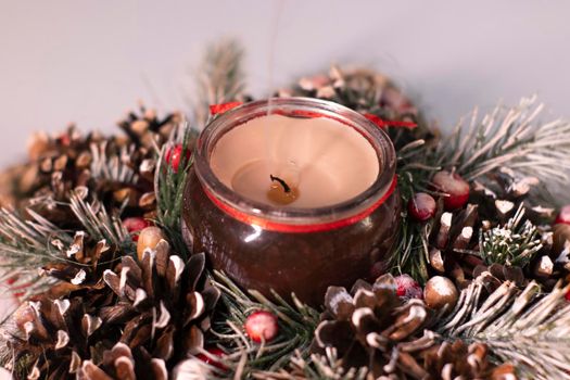 Christmas decor star-shaped made of tree branch with new years toys on it and a candle in it.