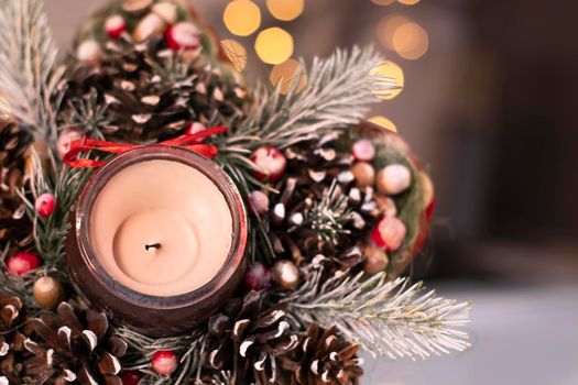 Christmas decor star-shaped made of tree branch with new years toys on it and a candle in it.