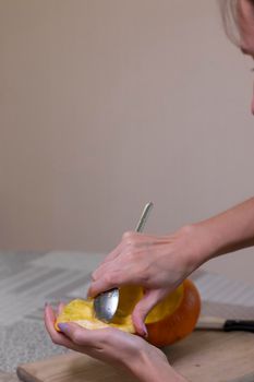 the process of making a Halloween pumpkin. cleansing of seeds by a brunette girl. horror theme and Hallowe'en.