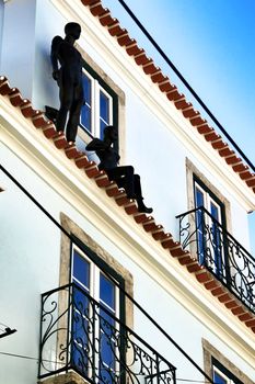 Colorful facade with two black mannequins in Lisbon in a sunny day of spring