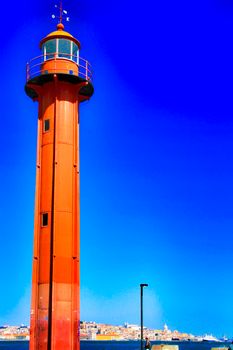 Red lighthouse in the port of Almada village in Lisbon on a sunny day of winter.