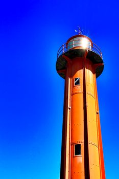 Red lighthouse in the port of Almada village in Lisbon on a sunny day of winter.