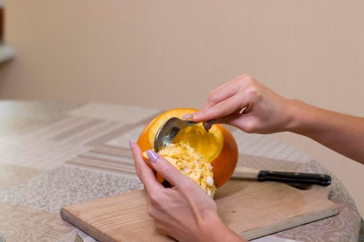 the process of making a Halloween pumpkin. cleansing of seeds by a brunette girl. horror theme and Hallowe'en.