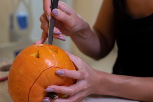 the process of making a Halloween pumpkin. cutting out the mouth. horror theme and Hallowe'en.