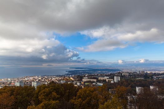 Stunning aerial panorama view of Lausanne cityscape with Lake Geneva (Lake Leman) in background from top of  Sauvabelin Tower on a cloudy autumn day with blue sky cloud, Canton of Vaud, Switzerland