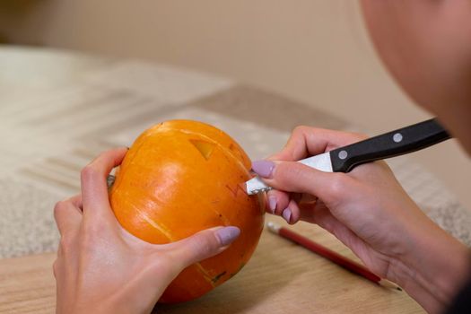 the process of making a Halloween pumpkin. cutting out the mouth. horror theme and Hallowe'en.