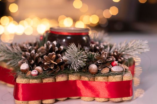 Christmas decor star-shaped made of tree branch with new years toys on it and a candle in it.