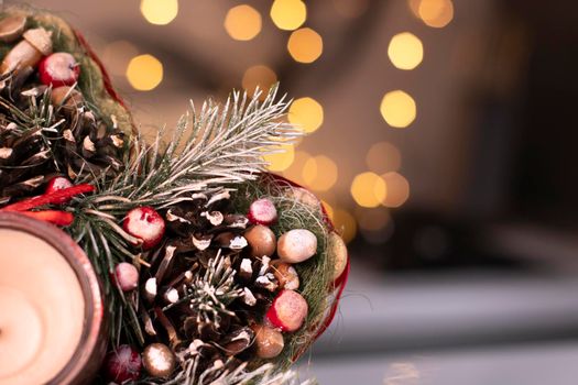 Christmas decor star-shaped made of tree branch with new years toys on it and a candle in it.