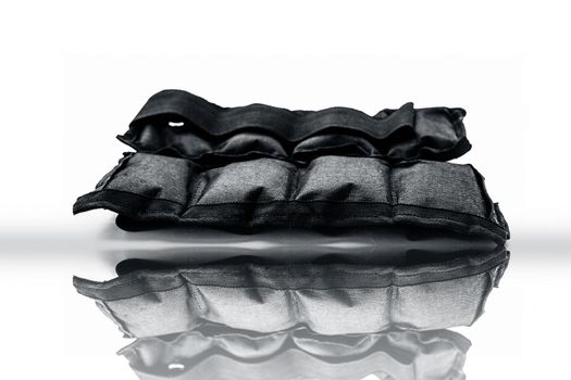 Black colored ankle weights isolated on white.