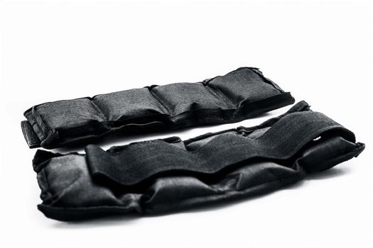 Black colored ankle weights isolated on white.