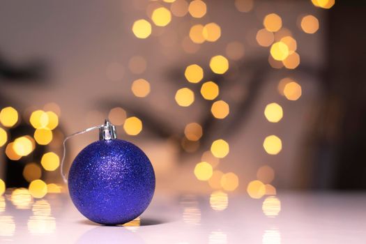 blue Christmas ball toy on a background of golden bokeh. new year theme.