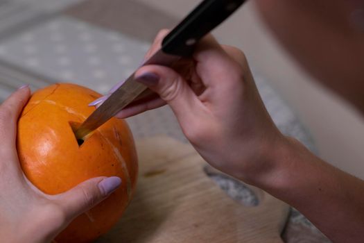 the process of making a Halloween pumpkin. cutting out eyes. horror theme and Hallowe'en.