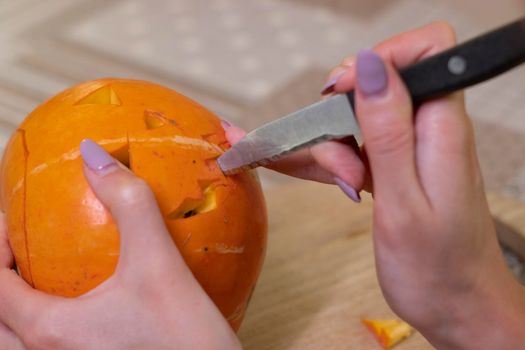 the process of making a Halloween pumpkin. cutting out the mouth. horror theme and Hallowe'en.