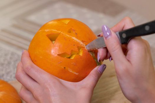 the process of making a Halloween pumpkin. cutting out the mouth. horror theme and Hallowe'en.