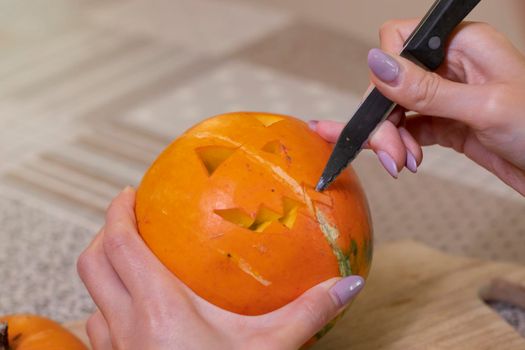 the process of making a Halloween pumpkin. cutting out the mouth. horror theme and Hallowe'en.