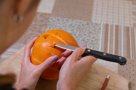 the process of making a Halloween pumpkin. cutting out the mouth. horror theme and Hallowe'en.