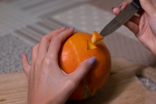 the process of making a Halloween pumpkin. cutting out eyes. horror theme and Hallowe'en.